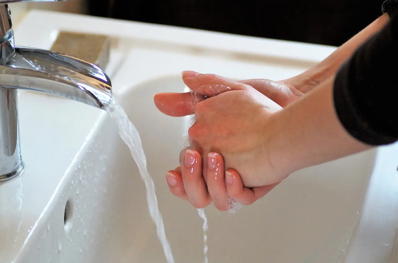 Hands being washed with soap under running water